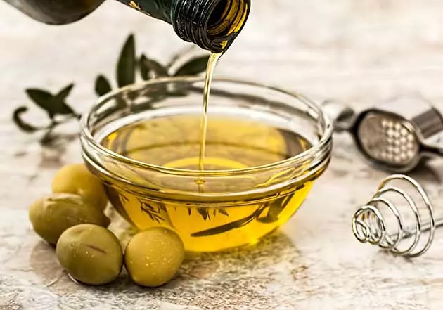 olio extravergine di oliva viene versato in una piccola ciotola di vetro