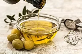 olio extravergine di oliva viene versato in una piccola ciotola di vetro