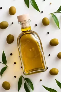 piccola bottiglia di olio extravergine di oliva con olive, pepe in grani e foglie di ulivo intorno